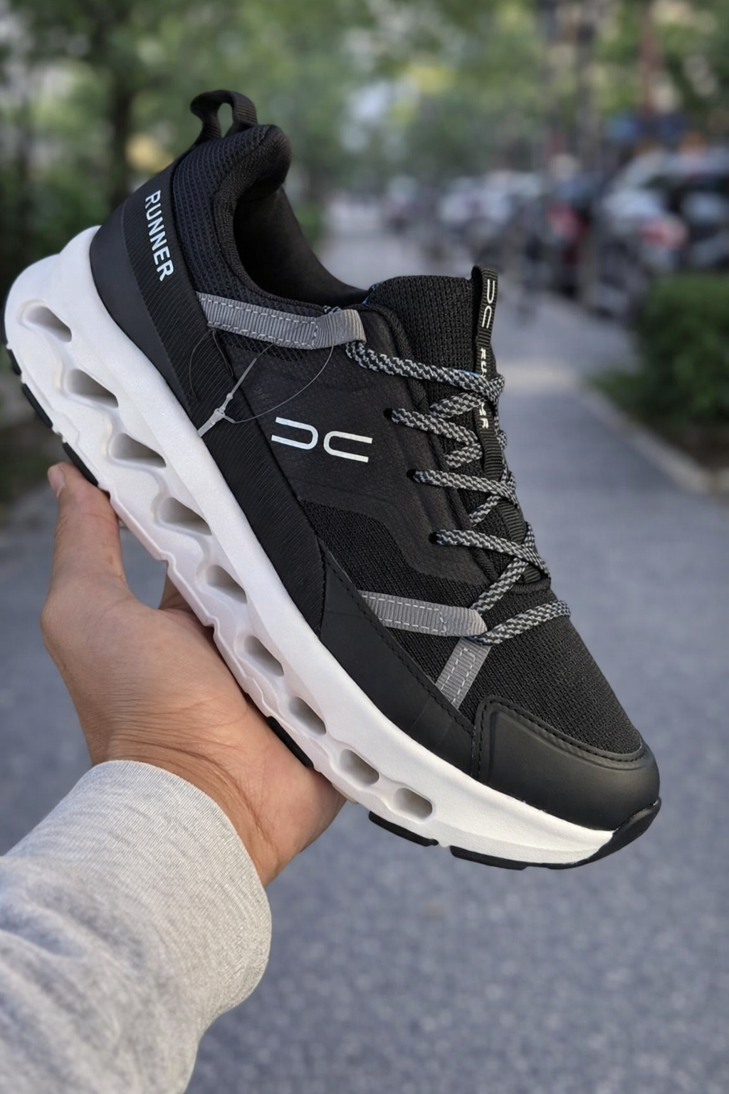 حذاء رياضي أسود مع لمسات بيضاء، يجمع بين الأناقة والراحة